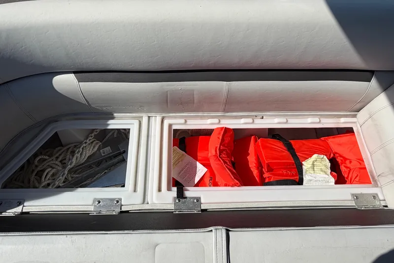 Slide: The Image of Storage compartment on 2022 Godfrey Sweetwater 2286FS boat with life jackets and rope. - 15