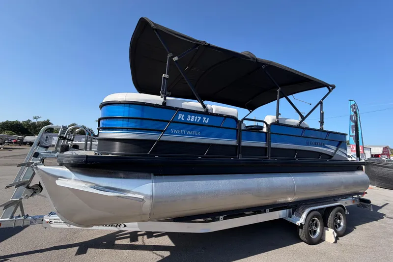 Slide: The Image of 2022 Godfrey Sweetwater 2286FS pontoon boat on trailer, featuring blue and black design. - 6