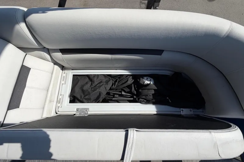 Slide: The Image of A seating area with storage underneath, filled with black items. - 18