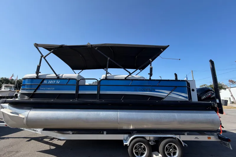 Slide: The Image of 2022 Godfrey Sweetwater 2286FS pontoon boat on trailer, featuring blue and black design. - 5