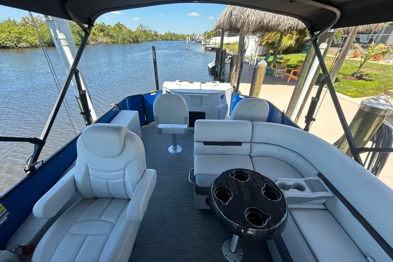 Slide: The Image of Interior of 2022 Godfrey Sweetwater 2286FS pontoon boat with plush seating and scenic waterway view. - 47