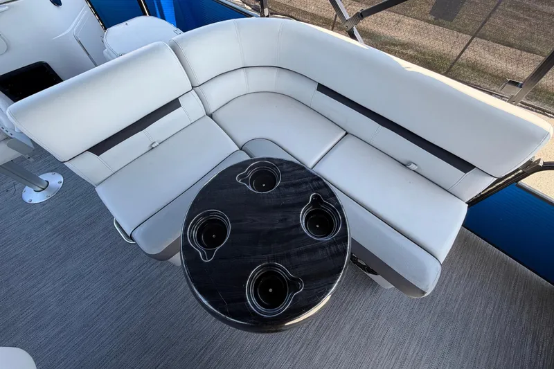 Slide: The Image of Interior view of a boat with a white corner bench and a round table with cup holders. - 38