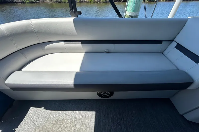 Slide: The Image of 2022 Godfrey Sweetwater 2286FS boat interior with sleek, modern seating by the water. - 62