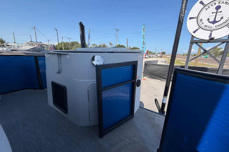 Slide: The Image of 2022 Godfrey Sweetwater 2286FS boat interior with blue paneling and outdoor setting. - 45