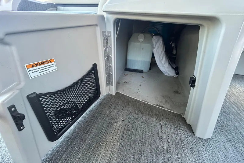 Slide: The Image of Storage compartment of 2022 Godfrey Sweetwater 2286FS boat with warning label and items inside. - 70