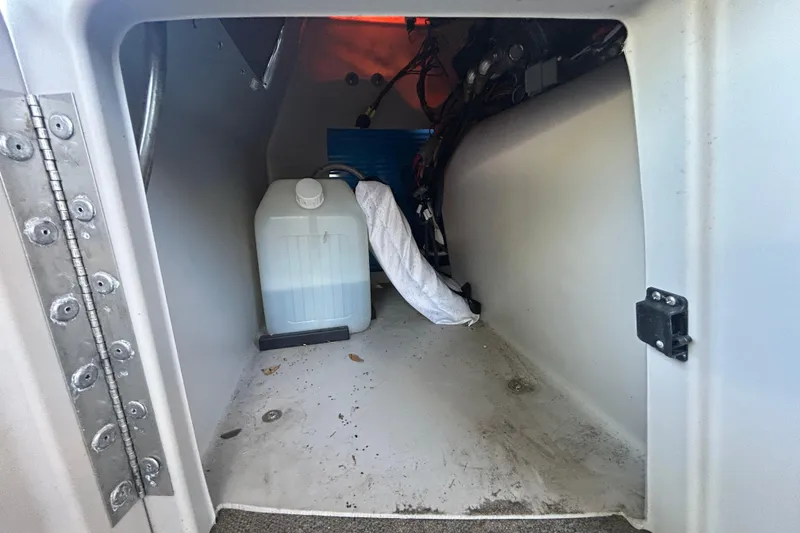 Slide: The Image of Storage compartment of 2022 Godfrey Sweetwater 2286FS boat with a water container. - 71