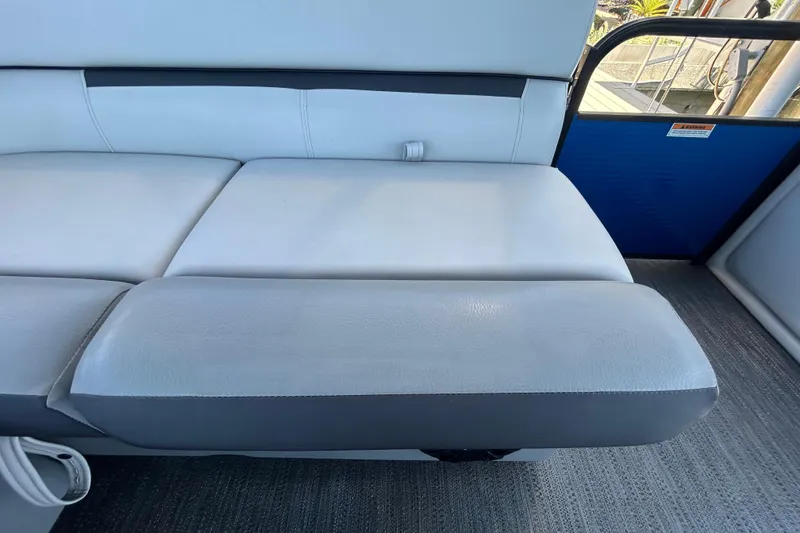 Slide: The Image of 2022 Godfrey Sweetwater 2286FS boat interior seating, featuring sleek white upholstery. - 74