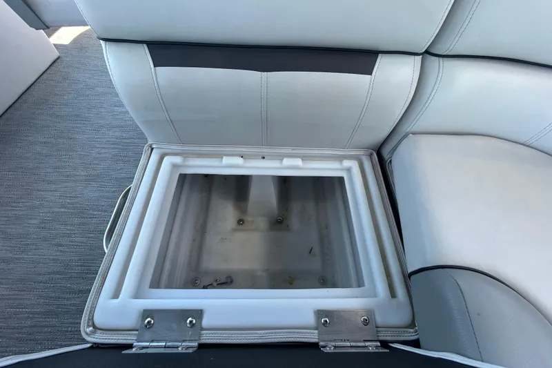 Slide: The Image of Open storage compartment on 2022 Godfrey Sweetwater 2286FS boat with cushioned seating. - 81