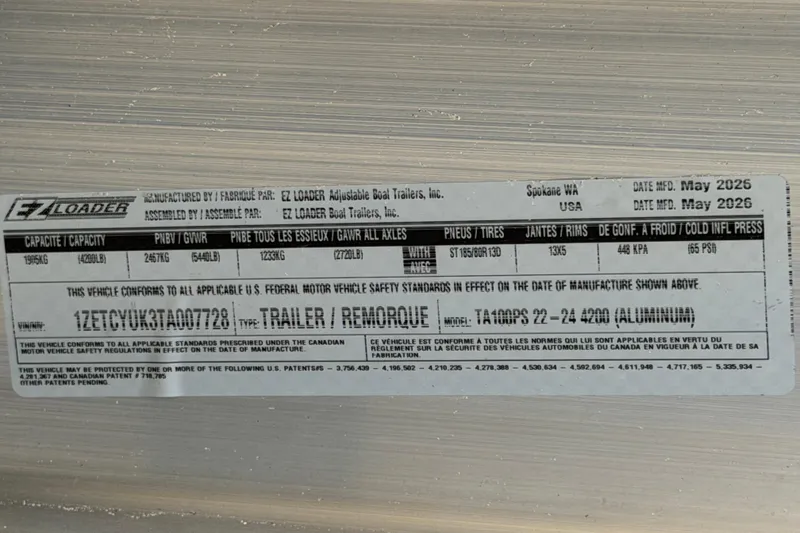 Slide: The Image of Label on EZ Loader trailer, manufactured May 2026, showing capacity and specifications. - 80