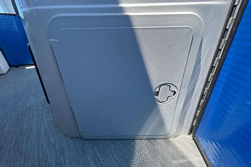 Slide: The Image of Storage compartment on a 2022 Godfrey Sweetwater 2286FS boat, featuring a secure latch. - 95