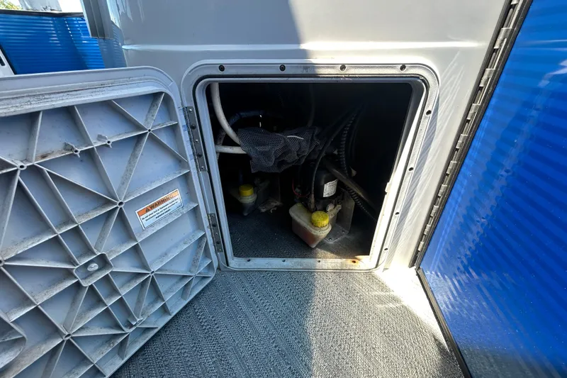 Slide: The Image of Open compartment of 2022 Godfrey Sweetwater 2286FS boat showing internal components and wiring. - 96