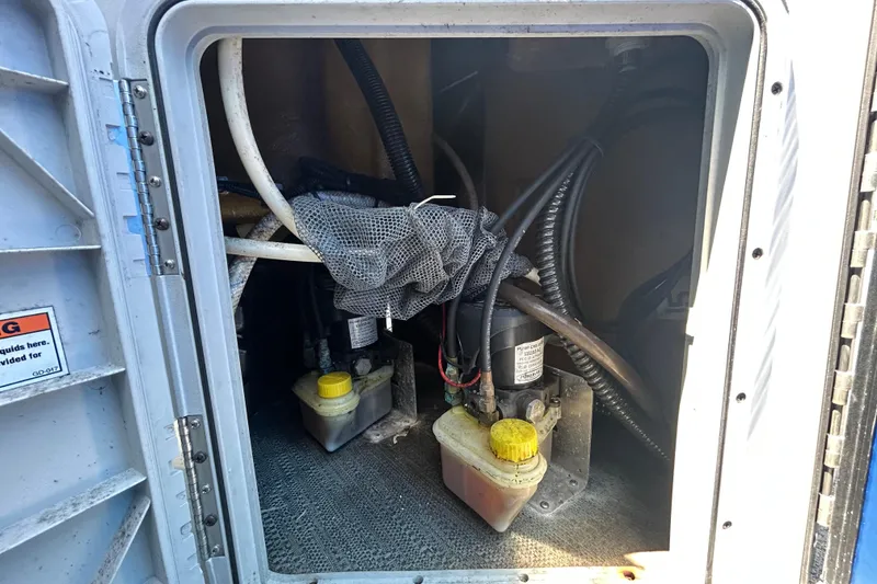 Slide: The Image of 2022 Godfrey Sweetwater 2286FS boat compartment with hydraulic components and wiring. - 97