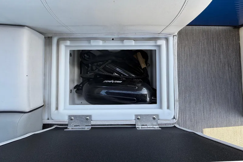 Slide: The Image of An open storage compartment on a boat reveals a Mercury outboard motor. - 39