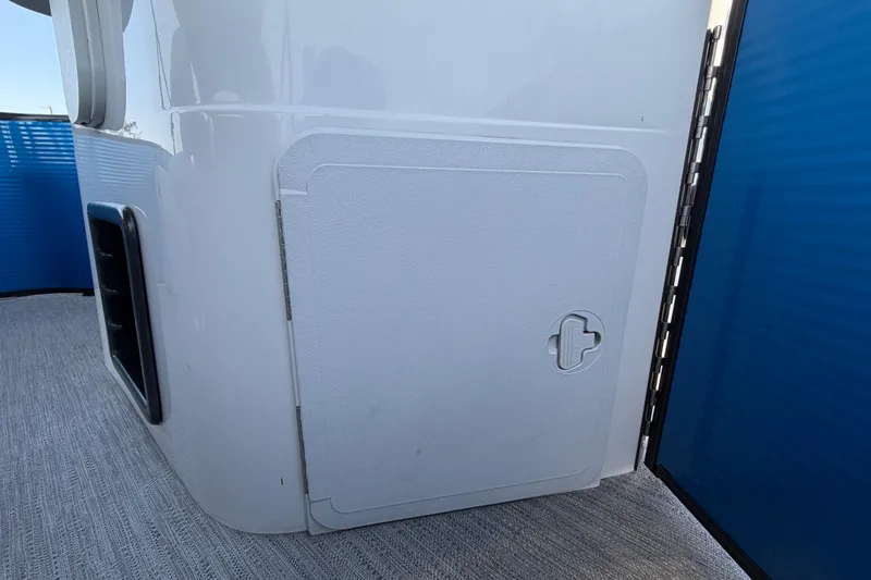 Slide: The Image of 2022 Godfrey Sweetwater 2286FS boat storage compartment with sleek white finish and secure latch. - 60