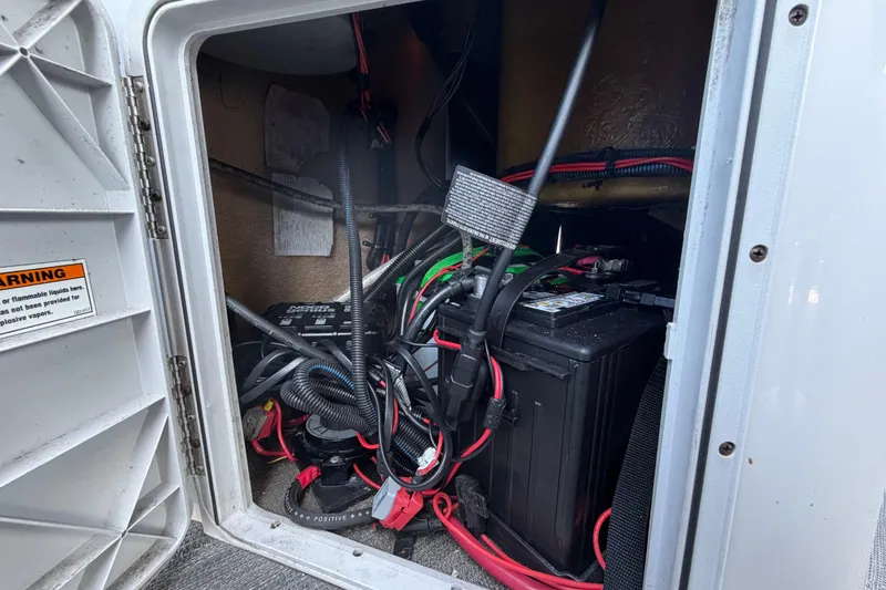 Slide: The Image of Electrical compartment of a 2022 Godfrey Sweetwater 2286FS boat with battery and wiring. - 56