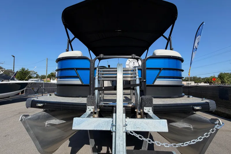 Slide: The Image of 2022 Godfrey Sweetwater 2286FS pontoon boat with blue accents, parked on a trailer. - 7