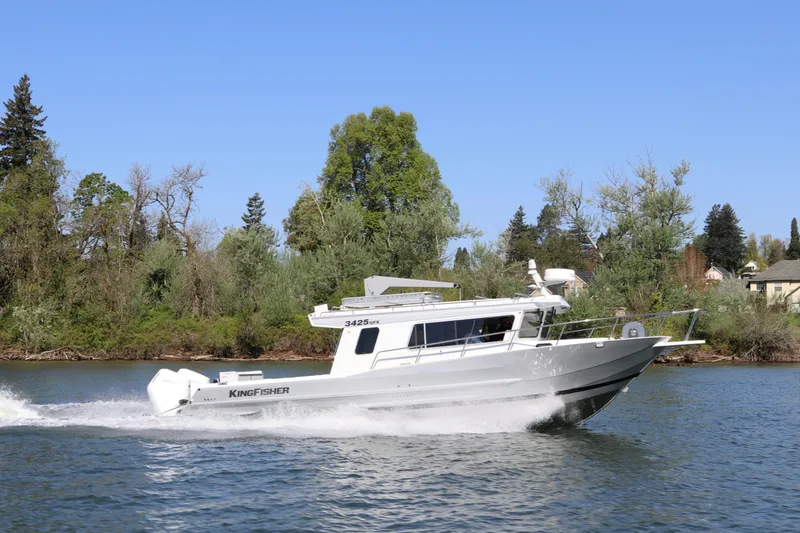 The Image of 2026 KingFisher 3425 GFX Offshore boat cruising on a scenic river. - 0