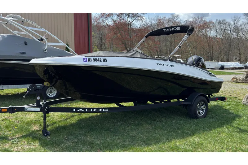The Image of 2025 Tahoe T18 boat on trailer, parked on grass, with cover and canopy. - 0