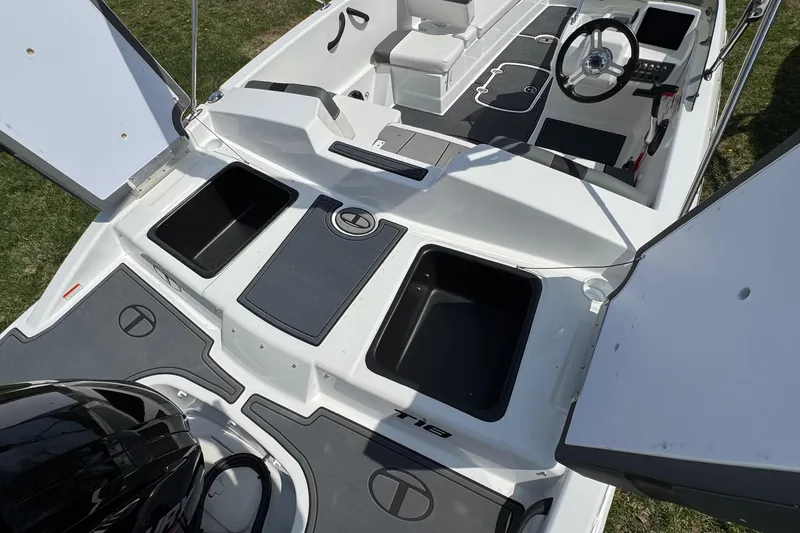 Slide: The Image of 2025 Tahoe T18 boat interior with open storage compartments and steering wheel. - 17