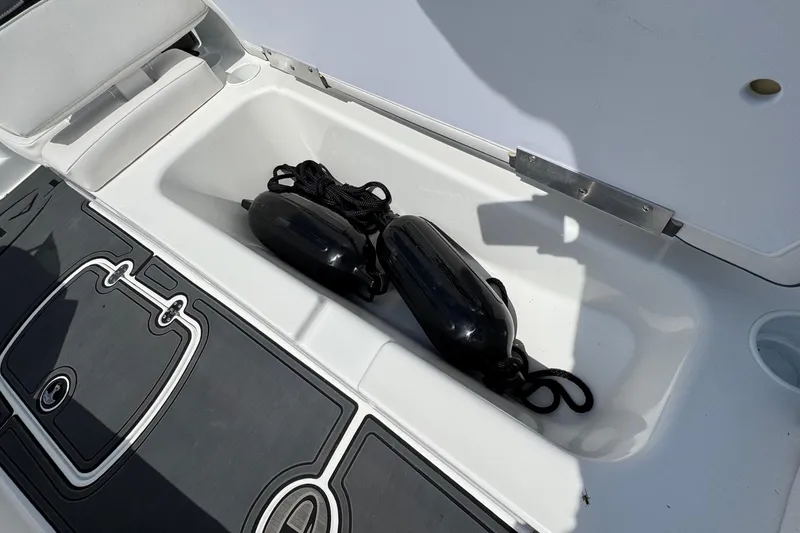 Slide: The Image of Open storage compartment in 2025 Tahoe T18 boat with black fenders inside. - 20