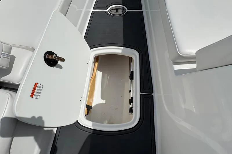Slide: The Image of Open storage compartment on 2025 Tahoe T18 boat deck, featuring sleek design and white seating. - 23