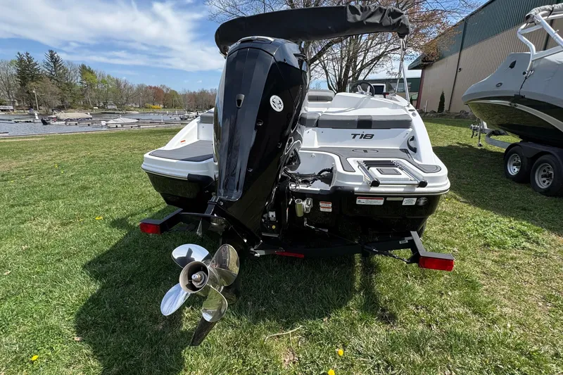 Slide: The Image of 2025 Tahoe T18 boat with outboard motor on grassy area near water. - 3