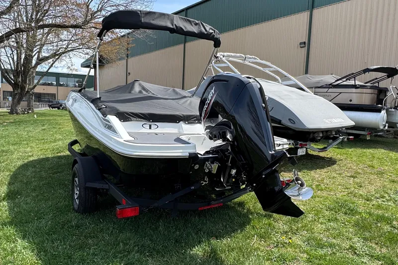 Slide: The Image of 2025 Tahoe T18 boat with Mercury outboard motor on trailer, parked on grass. - 4