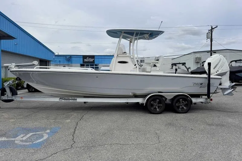 The Image of 2023 Pathfinder 2600 HPS boat on trailer, parked outside a blue building. - 1
