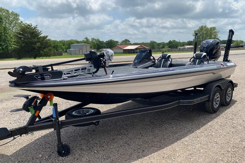 Slide: The Image of 2026 Skeeter ZXE20 fishing boat on trailer, parked outdoors under cloudy sky. - 3