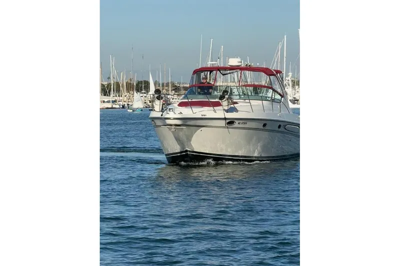 The Image of 1998 Maxum 3700 SCR yacht cruising in a marina with sailboats in the background. - 0