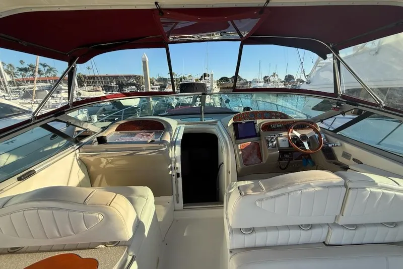 Slide: The Image of 1998 Maxum 3700 SCR yacht interior with white seating and wooden dashboard at marina. - 15