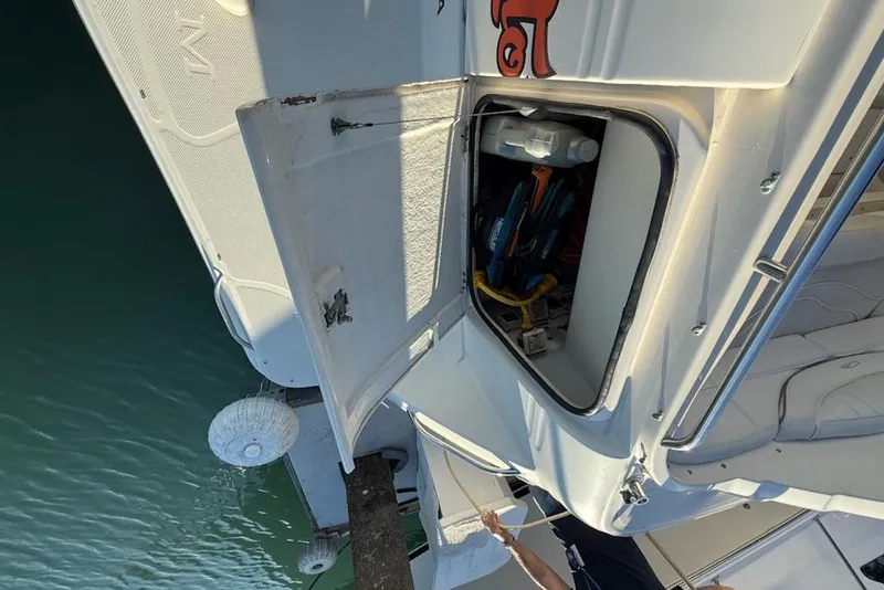Slide: The Image of Open storage compartment on a 1998 Maxum 3700 SCR boat, docked by the water. - 16