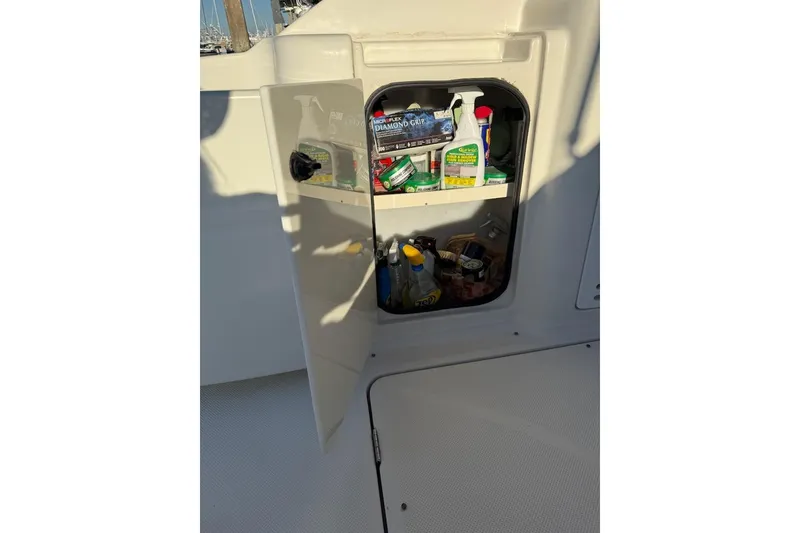 Slide: The Image of Open storage compartment on 1998 Maxum 3700 SCR boat, containing cleaning supplies. - 19