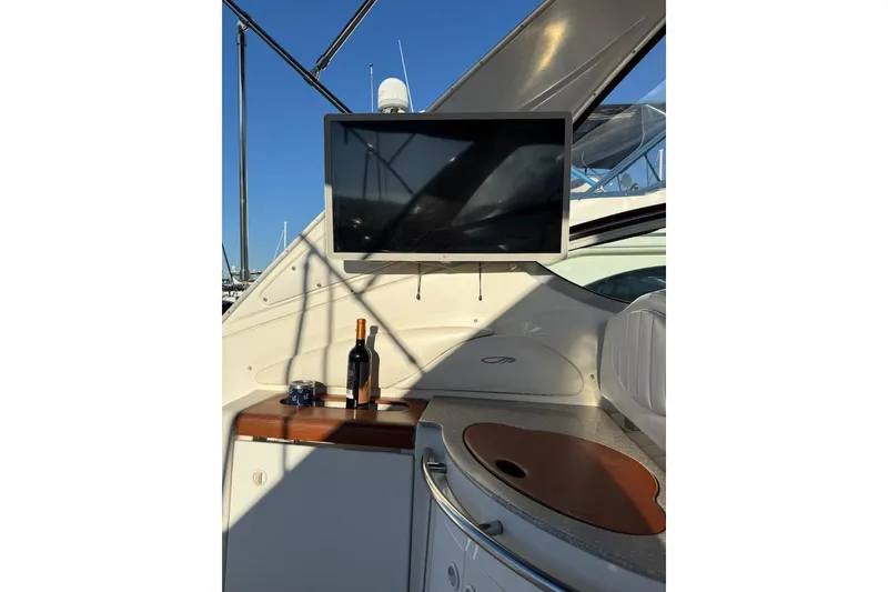 Slide: The Image of 1998 Maxum 3700 SCR yacht interior with TV, wine bottle, and cup on counter. - 21