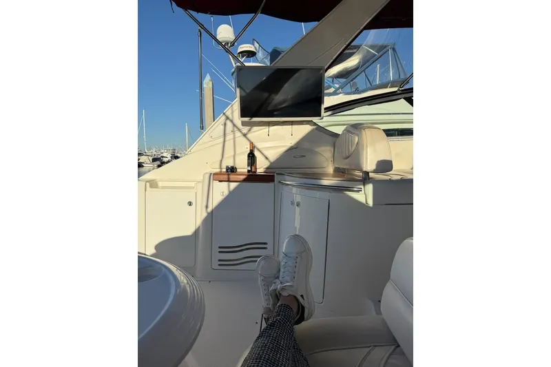 Slide: The Image of 1998 Maxum 3700 SCR yacht interior with relaxed seating and a bottle on the counter. - 22