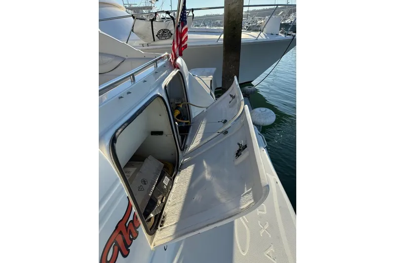 Slide: The Image of 1998 Maxum 3700 SCR boat with open storage compartments, docked in a marina. - 23