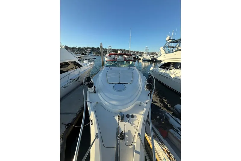 Slide: The Image of 1998 Maxum 3700 SCR yacht docked in a marina under clear blue skies. - 33