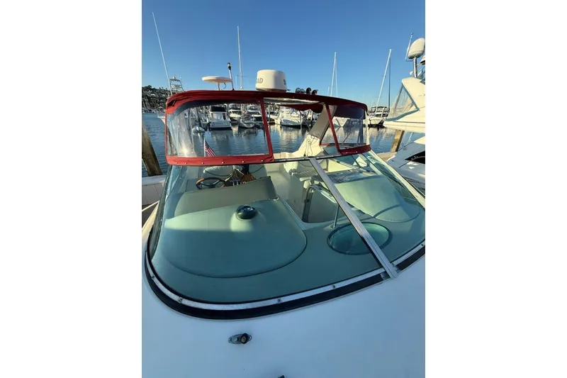 Slide: The Image of 1998 Maxum 3700 SCR boat docked at marina, featuring red trim and clear windshield. - 35