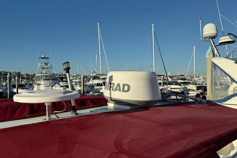 Slide: The Image of 1998 Maxum 3700 SCR boat with radar, docked in a marina under clear blue sky. - 36