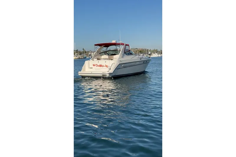 Slide: The Image of 1998 Maxum 3700 SCR boat on calm water with a red canopy. - 4