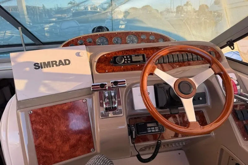Slide: The Image of 1998 Maxum 3700 SCR boat helm with Simrad navigation system and wooden steering wheel. - 44