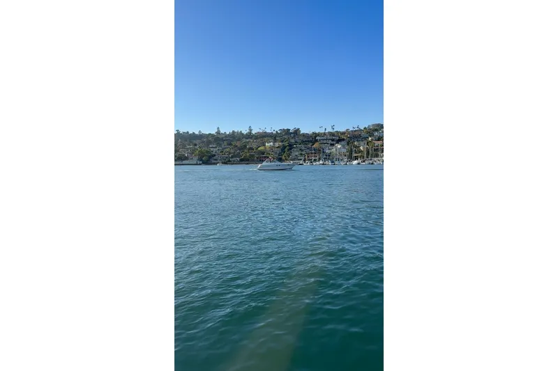 Slide: The Image of 1998 Maxum 3700 SCR yacht on calm water with scenic hillside background. - 5