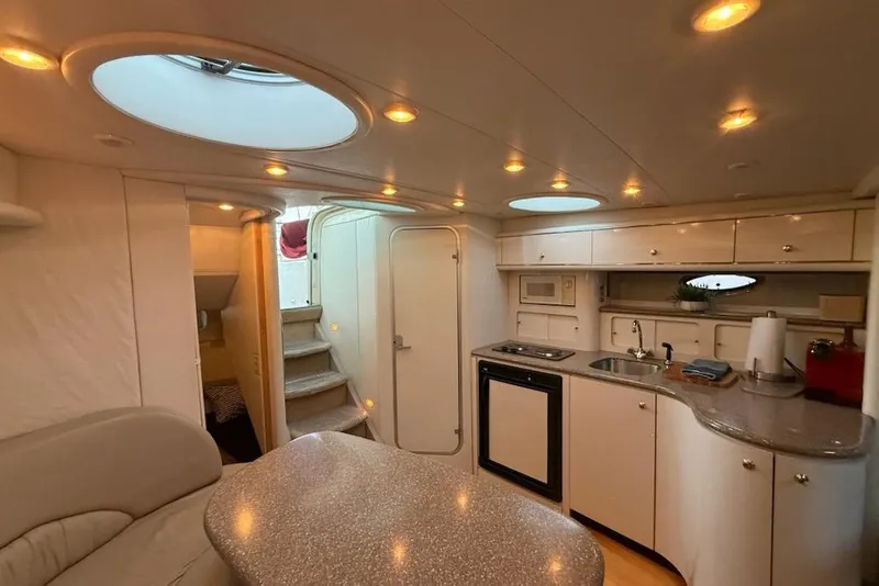 Slide: The Image of Interior of 1998 Maxum 3700 SCR yacht with kitchenette and seating area. - 51