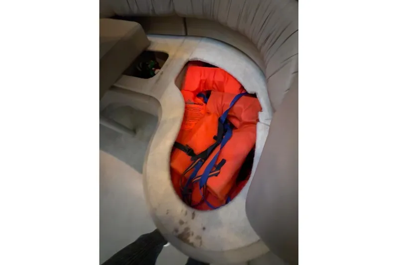 Slide: The Image of Storage compartment with orange life jackets on a 1998 Maxum 3700 SCR boat. - 56