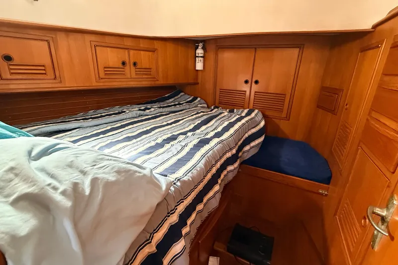 Slide: The Image of Cozy wooden cabin interior of 1983 Tanton 44 sailboat with striped bedding. - 11