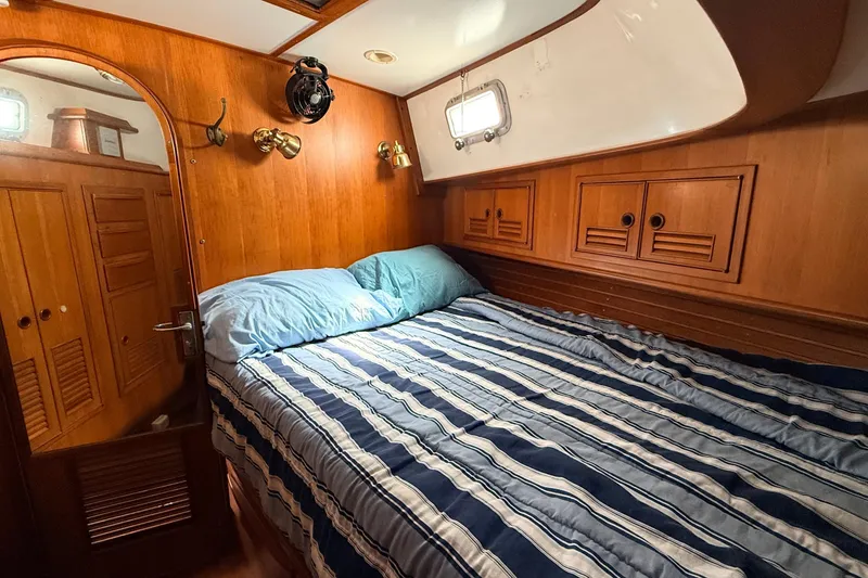 Slide: The Image of Cozy cabin interior of 1983 Tanton 44 sailboat with striped bedding and wooden accents. - 12