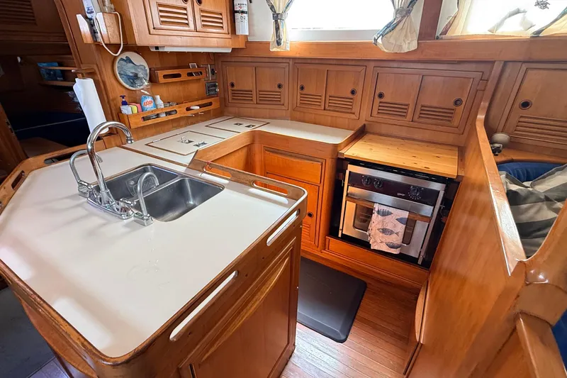 Slide: The Image of Wooden yacht kitchen interior with sink, stove, and storage; Tanton 44, 1983 model. - 14