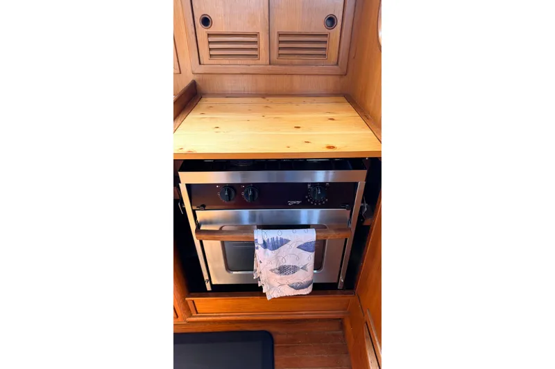 Slide: The Image of Wooden interior of 1983 Tanton 44 with built-in stainless steel oven. - 15