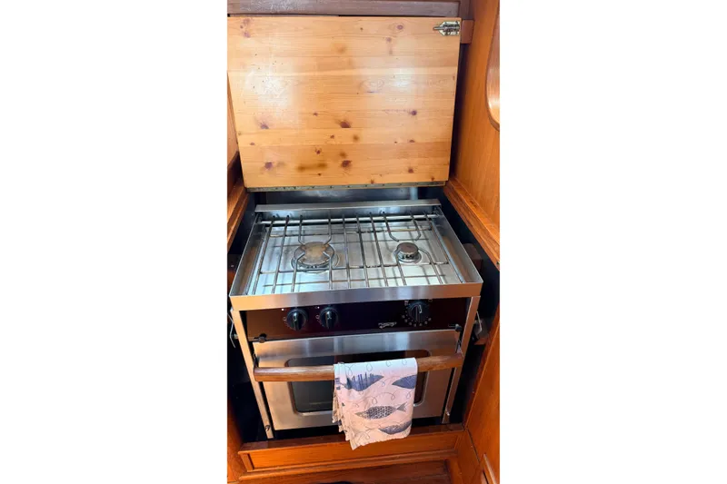 Slide: The Image of Vintage Tanton 44 stove from 1983 with wooden cover and towel, in a cozy kitchen setting. - 16