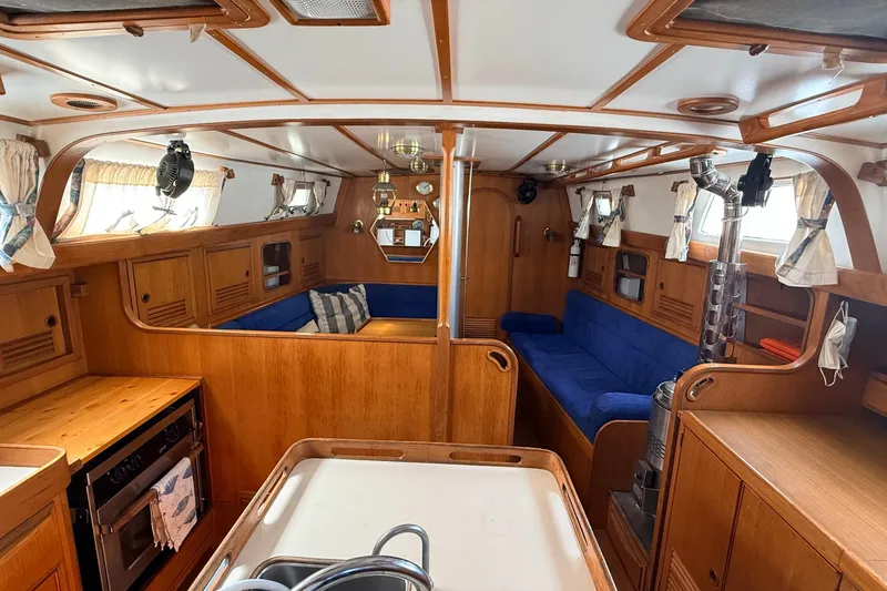 Slide: The Image of Interior of 1983 Tanton 44 sailboat with wooden finish and blue seating. - 2